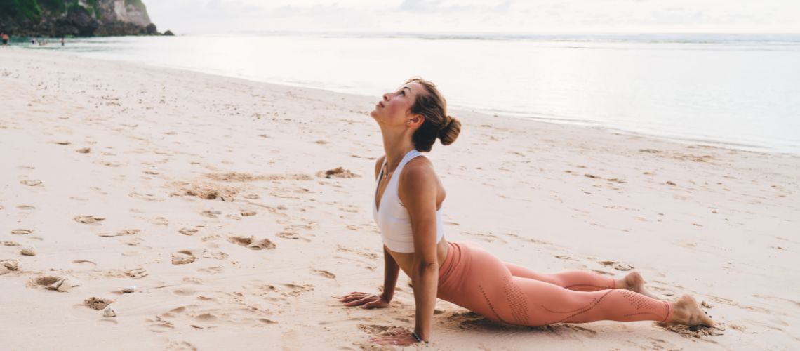 practica del bhujangasana en la playa