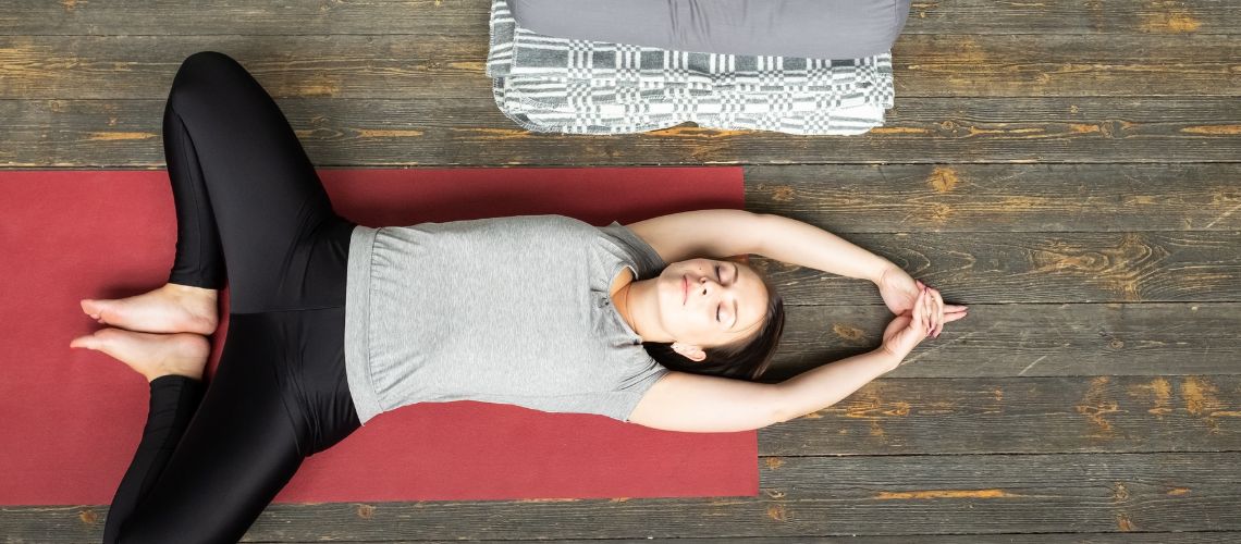 mujer practicando supta baddha konasana